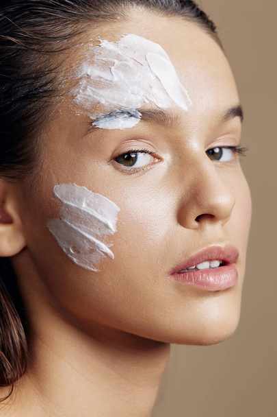 schöne Frau Anwendung einer beruhigenden Gesichtsmaske kosmetischen isolierten Hintergrund - Foto, Bild