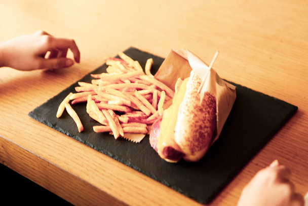 Lezzetli ev yapımı sosisli sandviç ve patates kızartması.  - Fotoğraf, Görsel
