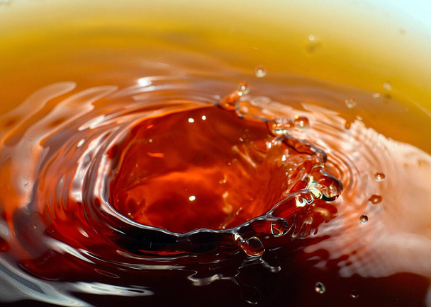 a drop of strong liquor falls on the surface of a liquid - Фото, зображення