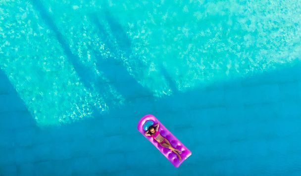 niña flota en un colchón inflable en la piscina
 - Foto, imagen