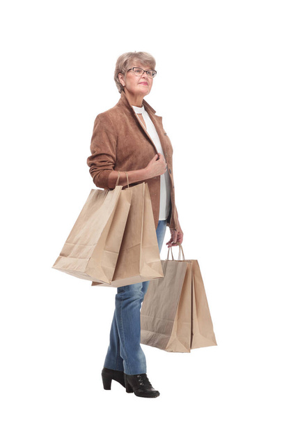 Side view full length portrait of a Senior woman walking with shopping bags - Фото, зображення