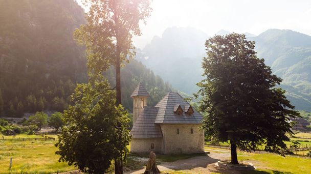 Καθολική Εκκλησία στο χωριό Θέθ της Προκλετίε στα Καταραμένα Βουνά της Αλβανίας. Η κοινότητα βρίσκεται στο κέντρο του Theth National Park, μια περιοχή εξαιρετικής φυσικής ομορφιάς. - Φωτογραφία, εικόνα
