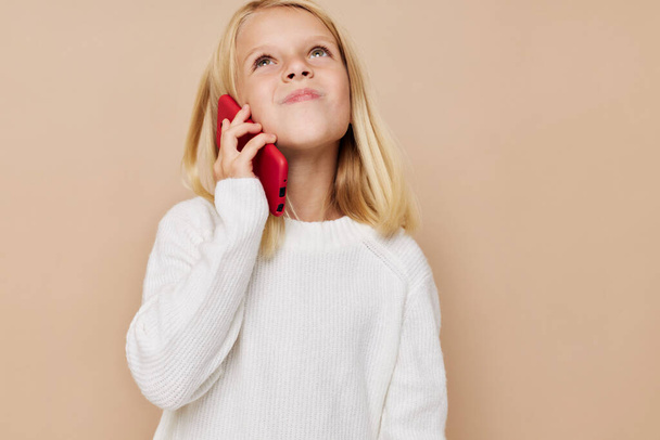 Красива маленька дівчинка розмовляє по телефону технології позує студію
 - Фото, зображення