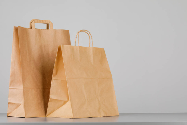 Коричневий паперовий мішок з ручками, порожня торгова сумка з площею для вашого логотипу або дизайну, концепція доставки їжі
 - Фото, зображення
