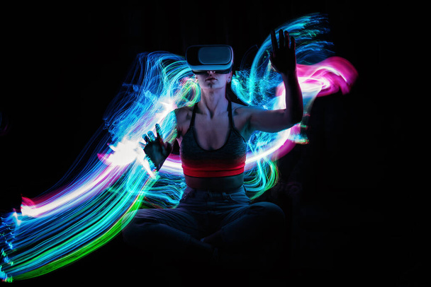 Metaverse digital Avatar, Metaverse Presence, digital technology, cyber world, virtual reality, futuristic lifestyle. Woman in VR glasses playing AR augmented reality NFT game with neon blur lines - Фото, зображення