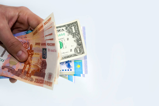 En las manos de la moneda de los diferentes países, el rublo, el dólar, tenge. - Foto, imagen