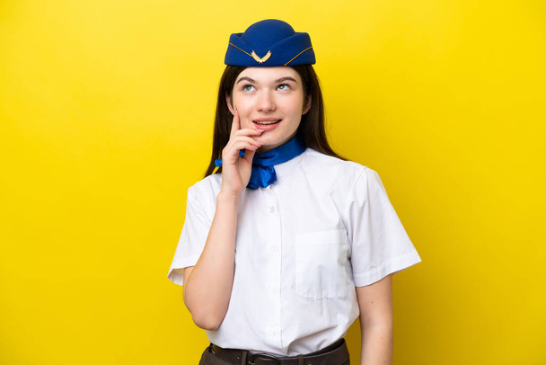 Letadlo letuška ruská žena izolované na žlutém pozadí myšlení nápad při pohledu nahoru - Fotografie, Obrázek