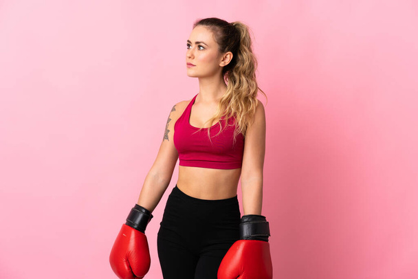 若いブラジルの女性は、ボクシングの手袋でピンクの背景に隔離 - 写真・画像