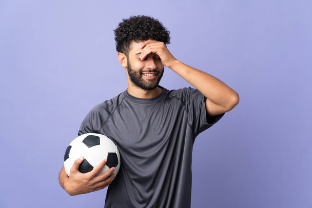 Bonito marroquino jovem jogador de futebol homem sobre isolado no fundo roxo sorrindo muito - Foto, Imagem