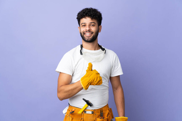 Young electrician Moroccan man isolated on purple background giving a thumbs up gesture - Foto, Imagem