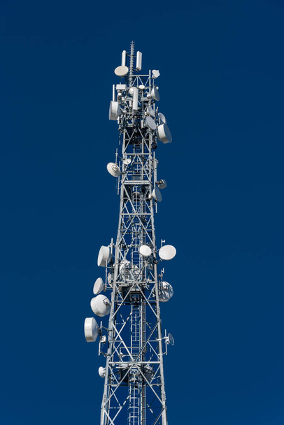 Металева вежа з телекомунікаційними антенами на блакитному небі, концепція високошвидкісної мережі 5G, вертикальна
, - Фото, зображення