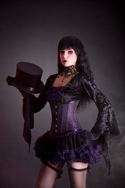 Magician assistant in purple and black gothic Halloween outfit - Foto, afbeelding