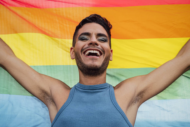 Boldog homoszexuális férfi ünnepli meleg büszkeség kezében szivárvány szimbólum LMBTQ közösség - Fotó, kép