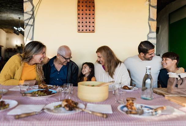 Ευτυχισμένη οικογένεια Λατίνων που διασκεδάζουν τρώγοντας μαζί στο σπίτι - Φωτογραφία, εικόνα