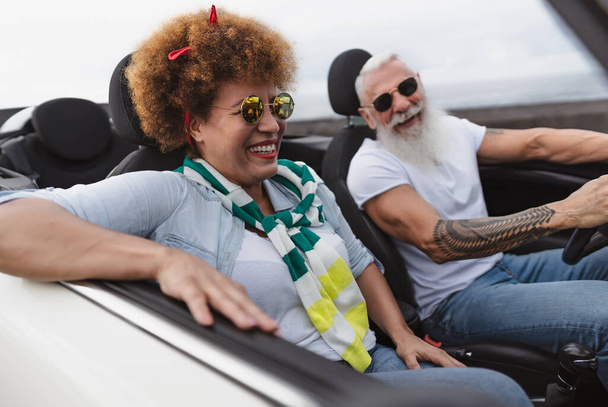 Ευτυχισμένο ηλικιωμένο ζευγάρι έχοντας διασκέδαση οδήγηση σε νέο μετατρέψιμο αυτοκίνητο - Ώριμοι άνθρωποι απολαμβάνοντας χρόνο μαζί κατά τη διάρκεια των διακοπών περιοδεία ταξίδι - Travel people lifestyle έννοια - Φωτογραφία, εικόνα
