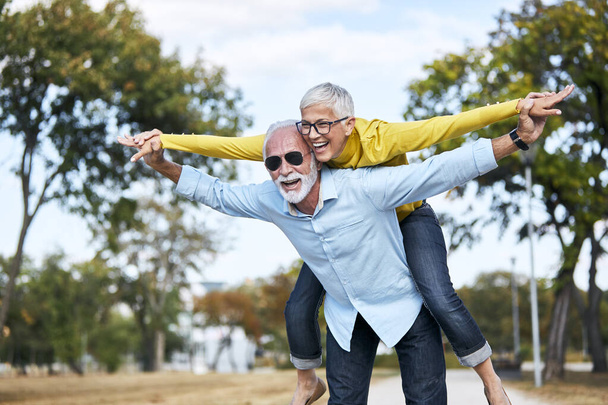 senior couple love together happy hug home family elderly man woman retirement smiling piggyback - Photo, Image