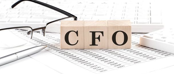 CFO written on wooden cube with keyboard , calculator, chart,glasses.Business - Foto, Bild