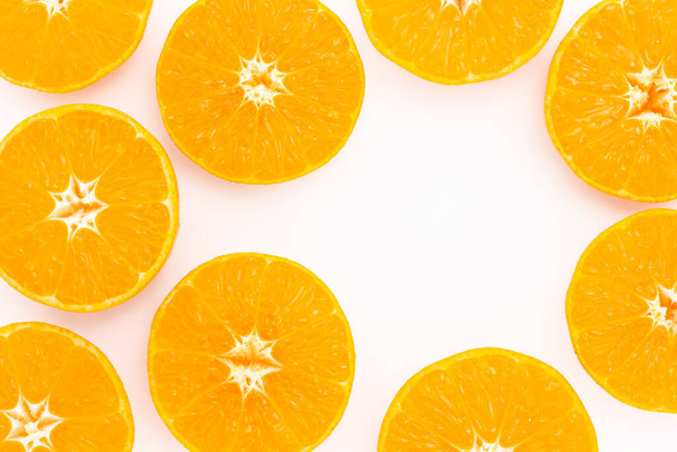 Fette succose di arancia o mandarino su fondo chiaro. Colorato sfondo creativo con spazio di copia. Vista dall'alto - Foto, immagini