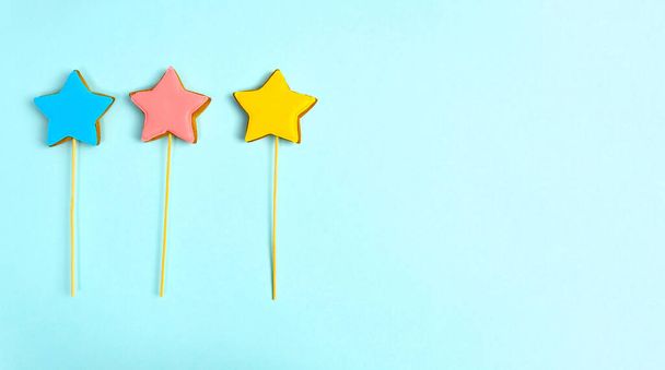 Ginger cookies on sticks in the form of stars. Festive dessert for the birthday. Free Space For Text. Blue Background. Flat lay - Fotó, kép