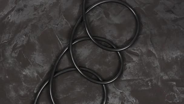 Black wire isolated on black and texture background. Top view. Loop motion. Rotation 360. 4K UHD video footage 3840X2160. - Footage, Video