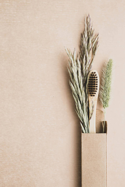 Zero waste bamboo toothbrush with dried flowers. Wooden personal dental care accessory. Plastic free, eco friendly, sustainable lifestyle concept. - Foto, afbeelding