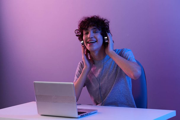man in headphones in front of laptop entertainment isolated background - Foto, afbeelding