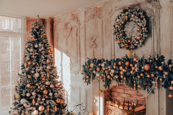 Accogliente camera a tema natalizio decorata con un albero di Natale, regali e un camino. Accogliente design degli interni invernali - Foto, immagini