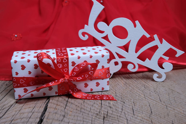 碑文の愛についてのギフトボックス赤の背景に。クリスマスやバレンタインデーへの贈り物。お祝いのカードおめでとう. - 写真・画像