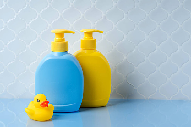 Zeep of shampoo flessen met schattige eend in de badkamer. Babybadaccessoires - Foto, afbeelding