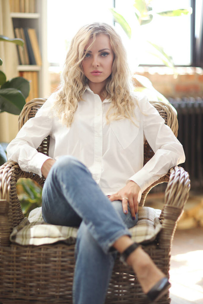 Beautiful woman in white shirt sitting on the chair - Photo, image