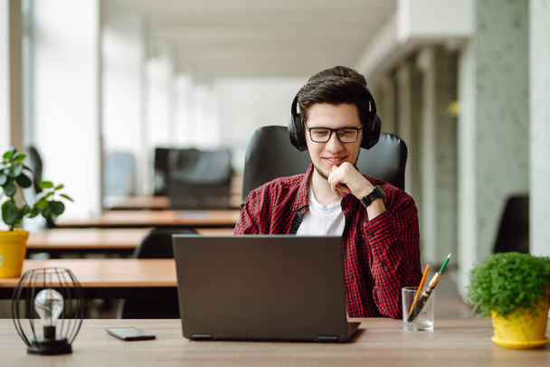 Education and working online. Young man with glasses working on laptop. Technology, Freelance, online course, remote work and lifestyle concept. - Zdjęcie, obraz
