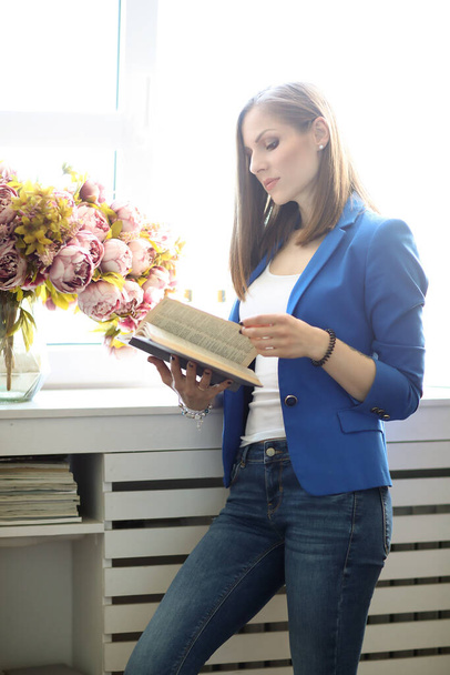 Lifestyle. Woman in blue jacket at home - Photo, Image