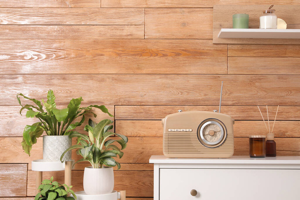 Stylish beige radio and interior elements near wooden wall indoors - Foto, Bild