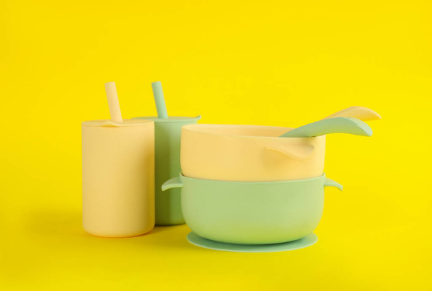 Set of plastic dishware on yellow background. Serving baby food - Valokuva, kuva