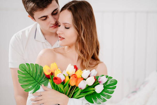 muž dal své milované ženě kytici barevných tulipánů. něžné objetí. - Fotografie, Obrázek