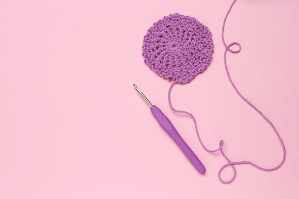 Knitting and crochet hook on pink background, flat lay. Space for text - Photo, Image