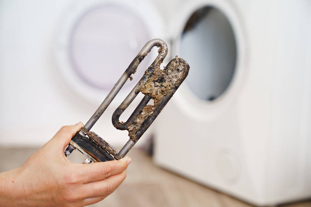 repair of washing machine. in hand old tubular electric heater - Foto, Imagem