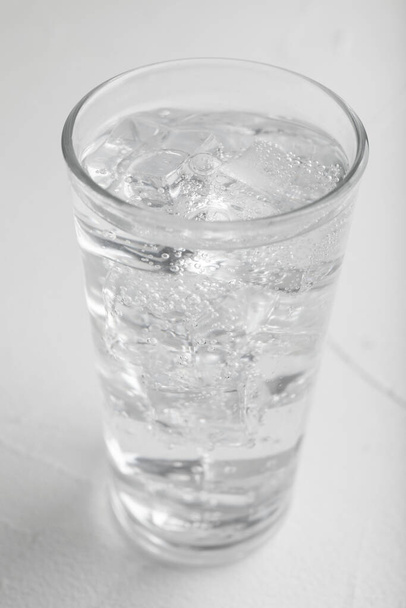 Glass of soda water on white table, closeup - Foto, afbeelding