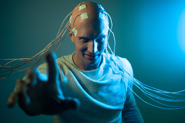 A scary young man with his head entangled in wires, uses mind control - Foto, immagini