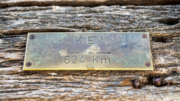 Direzione e distanza dal segno di metallo di Kiev su una parete di legno - Foto, immagini