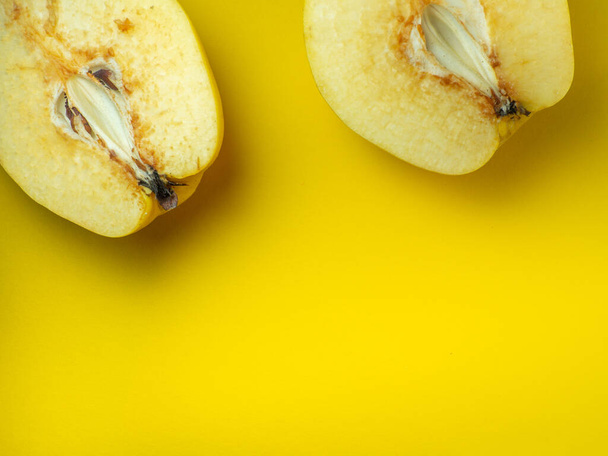 Quitten in Scheiben schneiden. Saftige Früchte auf gelbem Hintergrund. Reifes nützliches Produkt. Verwittertes Fruchtfleisch. Ernährung auf Diät. Verdunkelung der Schnittfrüchte - Foto, Bild