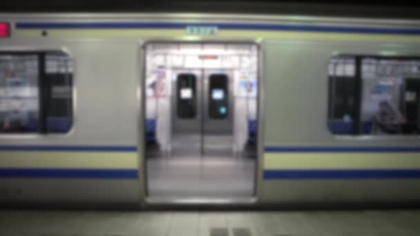 Tiro desenfocado de la puerta del tren cerrado en la plataforma Ferrocarril en Tokio, Japón. Metro de Asia. Estación de metro, transporte rápido y viajeros asiáticos. Fondo borroso en la escena - Imágenes, Vídeo