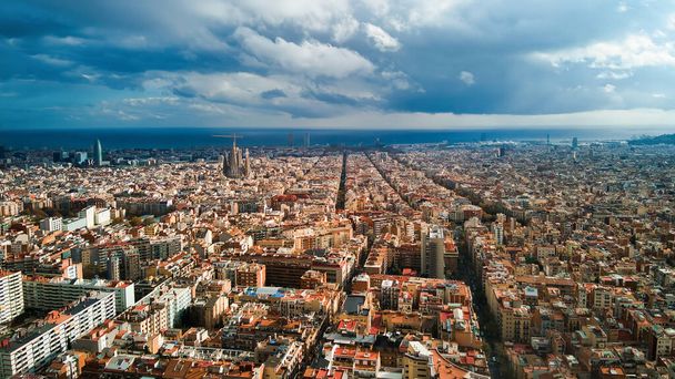 バルセロナ、スペインの空中ドローンビュー。遠くに複数の住宅建築物、緑、サグラダファミリアとブロック - 写真・画像