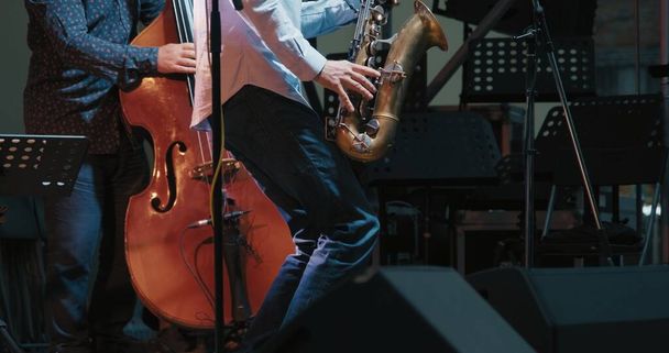 Hombres caucásicos en un concierto tocando jazz y blues en saxofón y contrabajo - Foto, imagen