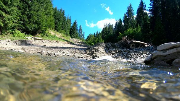 Schöne Berglandschaft mit fließendem Fluss und hellen Spiegelungen - Foto, Bild