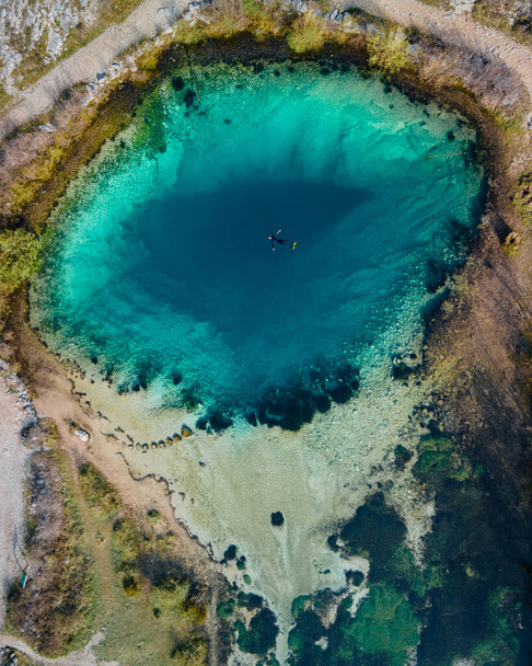 One diver in the blue hole Izvor Cetine, Dalmatia. Aerial top down shot in April, 2021. - Foto, Bild