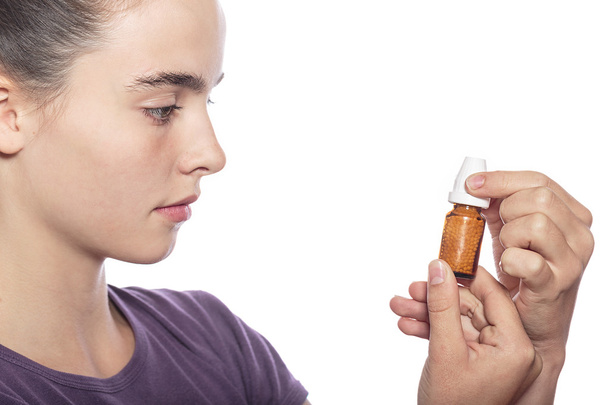 žena je zkoumat láhev homeopatické medicíny, izolovaných na w - Fotografie, Obrázek