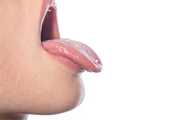 woman with a homeopathic globules on the tip of her tongue, isol - Photo, Image