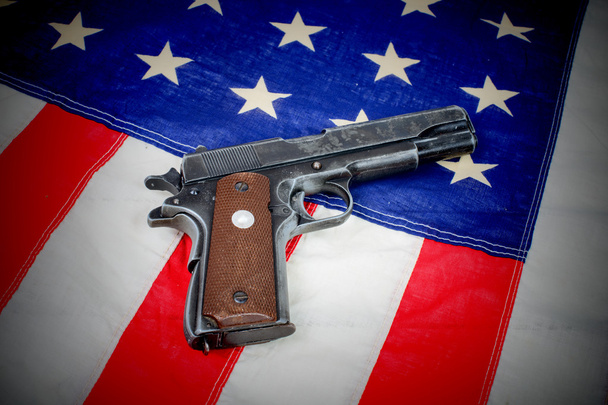 pistool gelegd op de Amerikaanse vlag - Foto, afbeelding