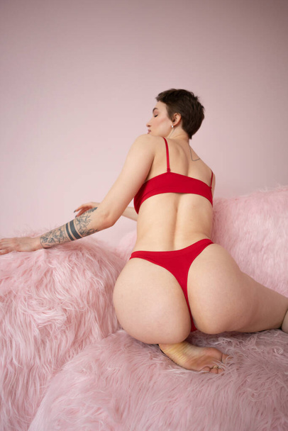 jeune belle femme pose en lingerie rouge en studio - Photo, image